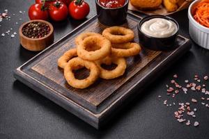 anéis de cebola fritos crocantes caseiros com molho de tomate foto