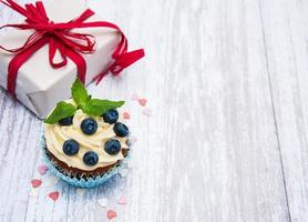 cupcakes com frutas frescas e caixa de presente foto