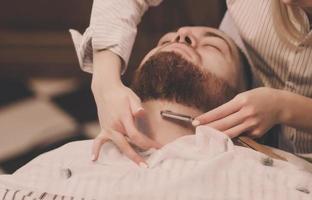 homem está se barbeando na barbearia