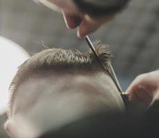 homem barbeiro no cabeleireiro masculino foto