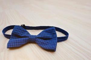 gravata borboleta xadrez azul sobre fundo claro de madeira foto