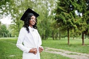 feliz linda garota afro-americana negra com graduados de chapéu foto