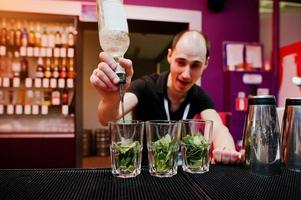 barman preparando coquetel mojito no bar foto