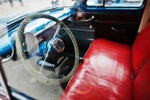 interior e volante com assentos de couro vermelho no velho carro retrô vintage foto