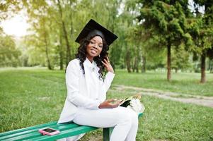 feliz linda garota afro-americana negra com graduados de chapéu foto
