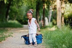 menina africana engraçada com saco grande no parque foto