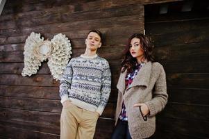 casal de inverno de moda jovem em fundo de madeira foto