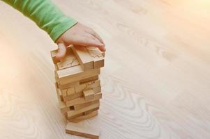 mão de bebê que jogou jogo de desenvolvimento de madeira de blocos de madeira foto