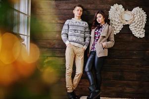 casal de inverno de moda jovem em fundo de madeira foto