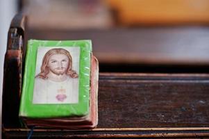 livro de orações com jesus cristo na capa no banco na igreja foto