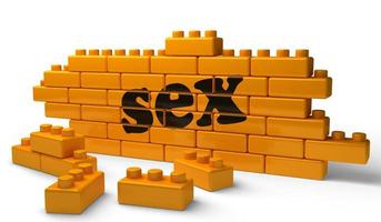 palavra de sexo na parede de tijolos amarelos foto