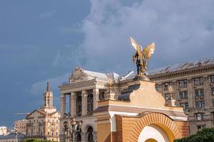 estátua de bronze banhada a ouro do arcanjo miguel na praça da cidade em dia ensolarado foto