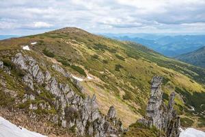 vista panorâmica do penhasco rochoso e colina contra cadeias de montanhas foto