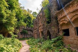 trilha pelo antigo forte abandonado cercado por plantas verdes em dia ensolarado foto