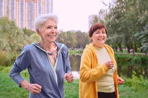 duas mulheres maduras correndo no parque. conceito de estilo de vida saudável foto