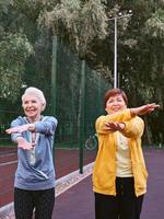 duas mulheres maduras fazendo exercícios esportivos no parque. conceito de estilo de vida saudável foto