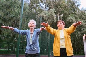 duas mulheres maduras fazendo exercícios esportivos no parque. conceito de estilo de vida saudável foto