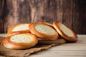 pães caseiros com requeijão em fundo de madeira. foto