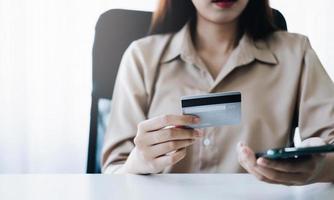 pagamento online, mãos de mulher segurando smartphone e usando cartão de crédito para compras online. conceito de segunda-feira cibernética