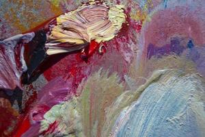 paleta de arte. close-up de uma paleta de arte com tintas coloridas misturadas. textura de pintura a óleo, fundo colorido pintado. foto