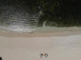 vista aérea das belas ondas do mar azul quebrando na costa arenosa. foto