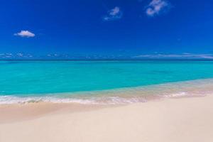 closeup de areia na praia e céu azul de verão. paisagem panorâmica da praia. praia tropical vazia e marinha. céu azul brilhante, areia fofa, calma, sol relaxante tranquilo, clima de verão foto