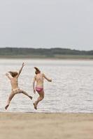meninas brincando ao longo da margem do lago foto