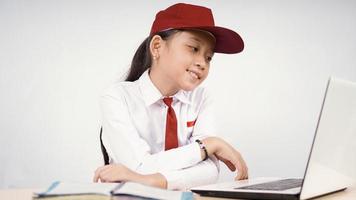 menina asiática do ensino fundamental estudando desfrutar isolado no fundo branco foto