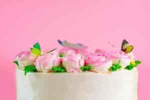 creme de manteiga de rosas decoradas oo bolo de baunilha em fundo rosa com espaço de cópia servido na festa de aniversário e casamento. deliciosa padaria doce para alguém que você ama. foto