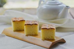 corte de cubo de bolo de manteiga na bandeja de madeira e mesa para servir na festa. deliciosa sobremesa comer com chá e café de manhã. foto