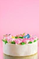 creme de manteiga de rosas decoradas oo bolo de baunilha em fundo rosa com espaço de cópia servido na festa de aniversário e casamento. deliciosa padaria doce para alguém que você ama. foto