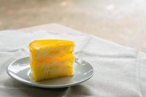 deliciosa fatia de bolo de laranja servido no prato branco em tempos de café na toalha de mesa. foto