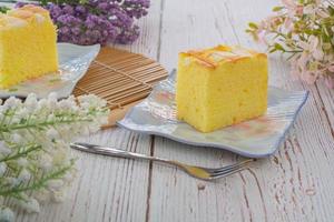 pedaço de bolo de coco chiffon de baunilha no prato quadrado na mesa de madeira. deliciosa pequena padaria para café e chá. foto