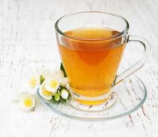 xícara de chá com flores de jasmim foto