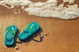 chinelos femininos ficam na praia na areia, conceito de férias