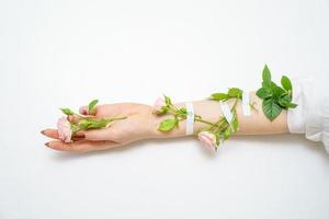 linda mão feminina com rosas cor de rosa em fundo branco, conceito de salão de beleza foto