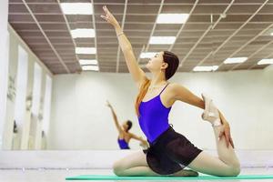 bailarina feminina em sapatilhas aquecendo no tapete foto