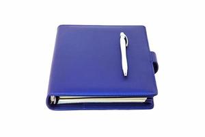 diário de colarinho azul e caneta colocada na capa e fundo branco. foto