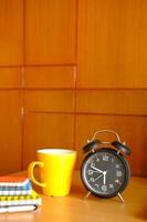 caneca de café e relógio na mesa fecham foto