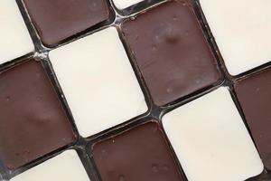 chocolate escuro e branco em uma caixa em fundo cinza foto