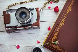 filme de foto de rolo de câmera retrô e flores em fundo branco de madeira