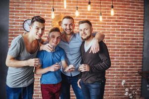 alegres velhos amigos se comunicam uns com os outros copos de uísque no pub. entretenimento de conceito e estilo de vida foto