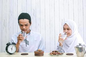 jovem casal muçulmano bebendo juntos na hora do iftar. ramadã tradicional, refeição iftar. conceito de mês de jejum ramadan kareem foto