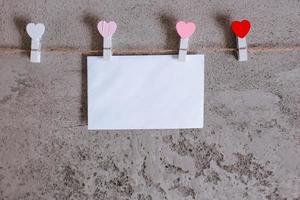 envelope branco preso na corda do varal com formato de mini coração foto