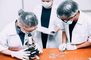 equipe de cientistas de pesquisa bioquímica trabalhando com microscópio para desenvolvimento de vacinas em laboratório de pesquisa farmacêutica. dia nacional da ciência, dia mundial da ciência foto