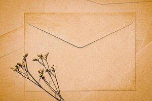 envelope de papel pardo com flor seca de limonium. close-up de envelope de artesanato. minimalismo plano leigo. foto
