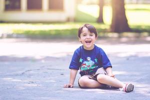 menino sorridente sentado no parque foto