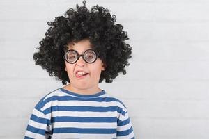 criança engraçada fazendo uma careta usando óculos nerd foto