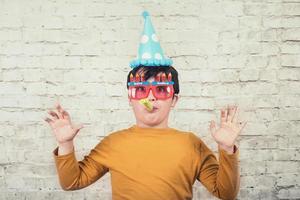 criança surpresa usando um chapéu de festa em seu aniversário foto