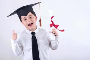 menino sorridente com diploma na formatura foto